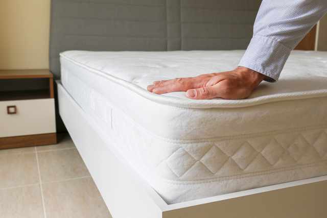 Comfortable Mattress Support Woman resting comfortably on a supportive mattress in a bright bedroom