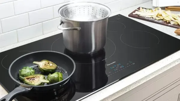 Credit: Thermador The Thermador Masterpiece CIT365YB cooktop featuring sauteing artichokes