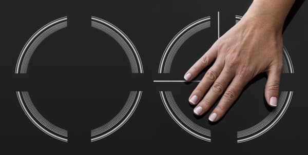 A person placing their hand atop an induction heating element 