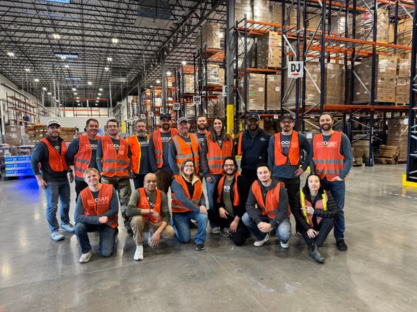 Kodiak Interiors Group in orange vests volunteering at Food Bank of the Rockies