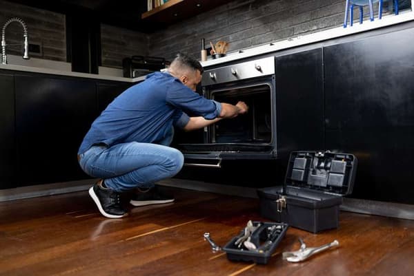 Spencer’s repair services Man repairing an oven