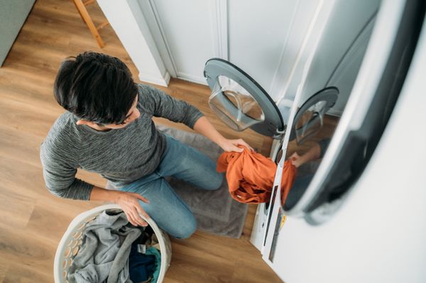 An overhead view of a man removing clothes from a washer