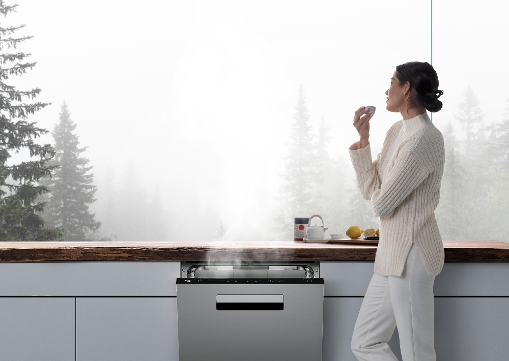 Beko A woman stands before her window next to a Beko dishwasher