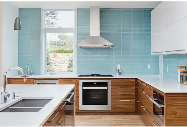 Front view of a modern kitchen with a wall mount range hood