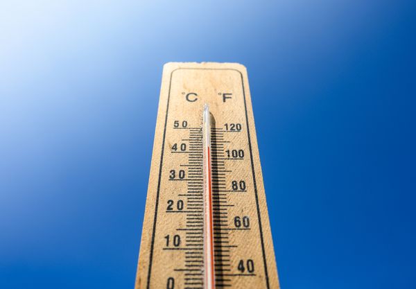 Long view of a thermometer against a blue background 