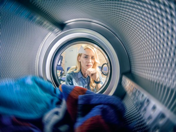 iStock Credit: bluecinema A concerned woman looking into a front load washer
