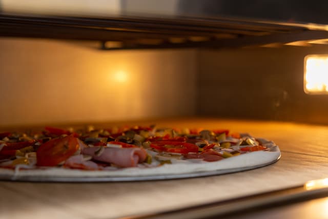 close view of a pizza cooking in an oven