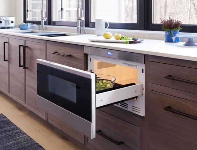 Front view of an opened microwave drawer in a modern kitchen