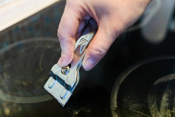 iStock Credit: VvoeVale A person using a razor on a glass cooktop