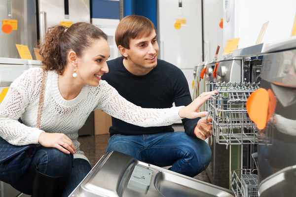 A man and a woman inspecting the inside of a refrigerator