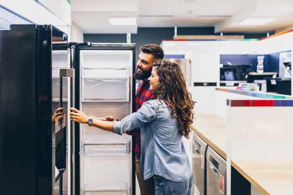 A man and a woman inspecting a refrigerator