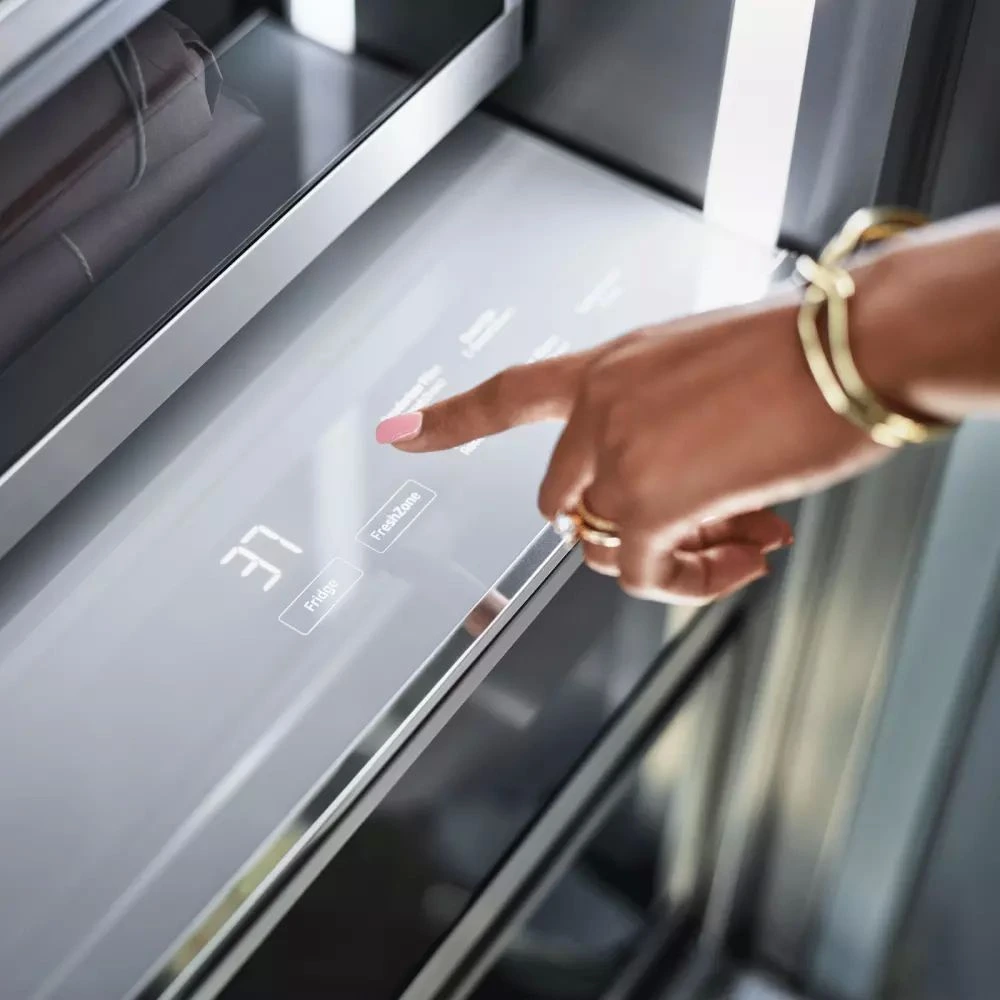 A woman using the Dacor DRR36980RAP refrigerator control panel