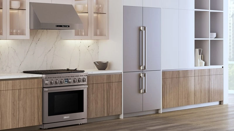 A kitchen featuring a Dacor range, range hood, and refrigerator