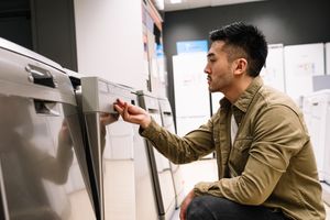 A man inspecting a dishwasher
