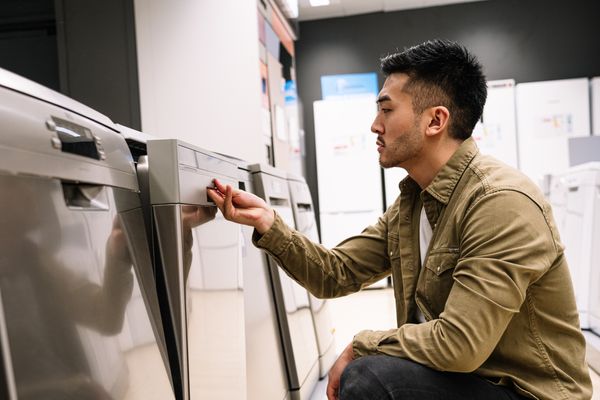 A man inspecting a dishwasher