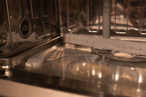 A close-up of a dishwasher with stagnant water