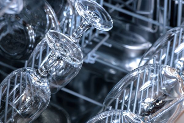 A close-up of dry wine glasses in a dishwasher 