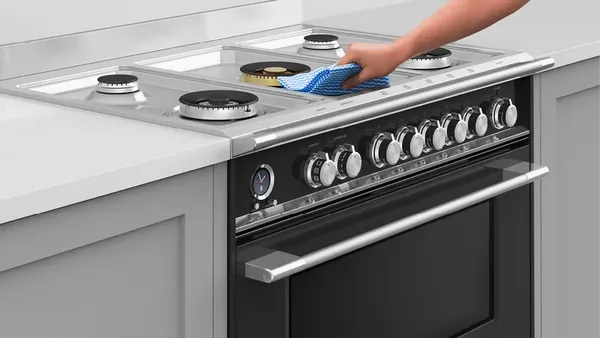 An open Fisher & Paykel OR36SCG6X1 dual fuel range with items inside 