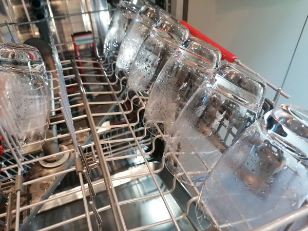 A close-up of humid drinking glasses in a dishwasher 