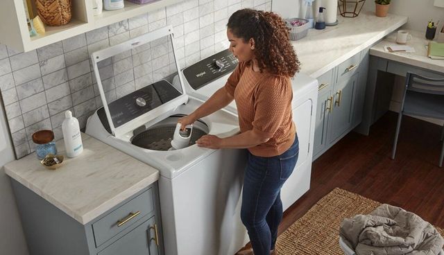 Credit: Whirlpool View of a woman taking the agitator out of her Whirlpool top load washer