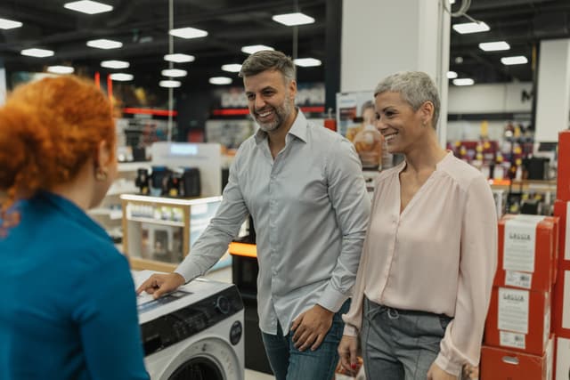 Credit: iStock Front view of a couple walking around an appliance showroom
