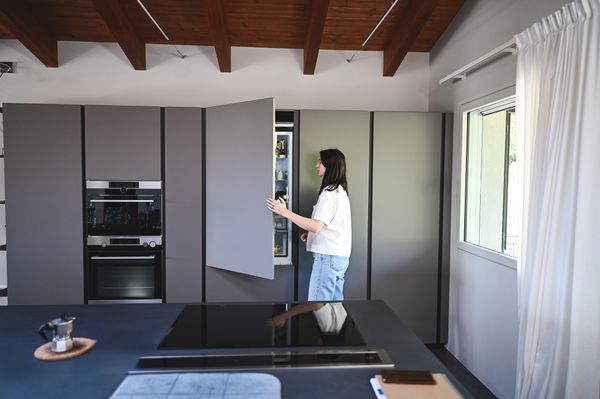 A woman looking inside of a custom panel refrigerator 