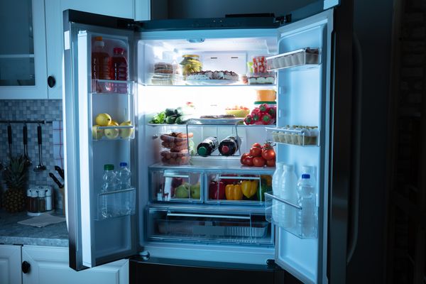 An open French door refrigerator stocked with food 