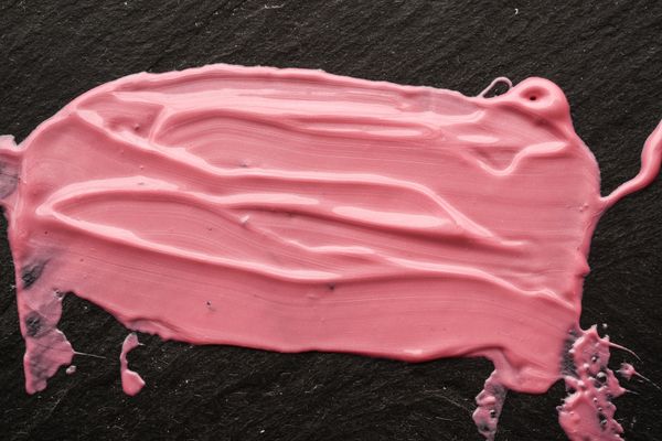 iStock Credit: YuraWhite Smeared pink paste on a black surface