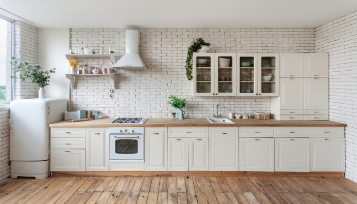 A cream, neutral colored kitchen with lots of cabinets and retro-inspired appliances.