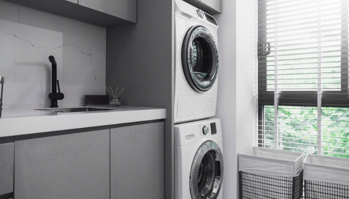A side-view of a laundry center in a neutral laundry room.