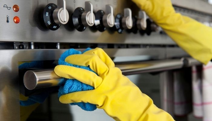 a stainless-steel oven being cleaned