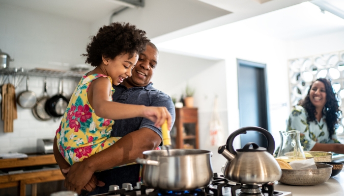 App_Cooktop-vs-Range_2.jpg Dad helping his kid stir the pot on the cooktop