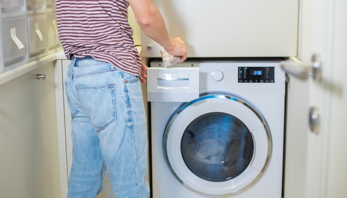 App_Laundry-Tech-Innovations_4.jpg Closeup of someone filling a high-efficiency washer with detergent