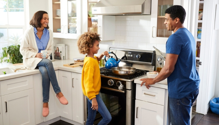 A family in the kitchen cooks together.