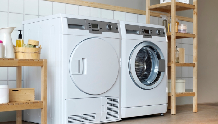 A modern laundry room with a white set of laundry appliances.