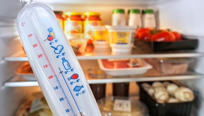 A thermometer takes the temperature of the fridge. 