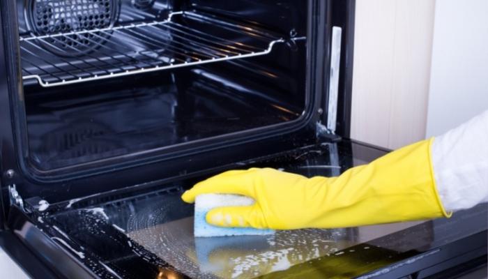 App_Places-Odors-Lurk_1.jpg Person cleaning oven
