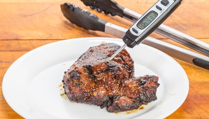 App_Indoor-BBQ-Guide_4.jpg BBQ meat with a meat thermometer indicating how hot it is