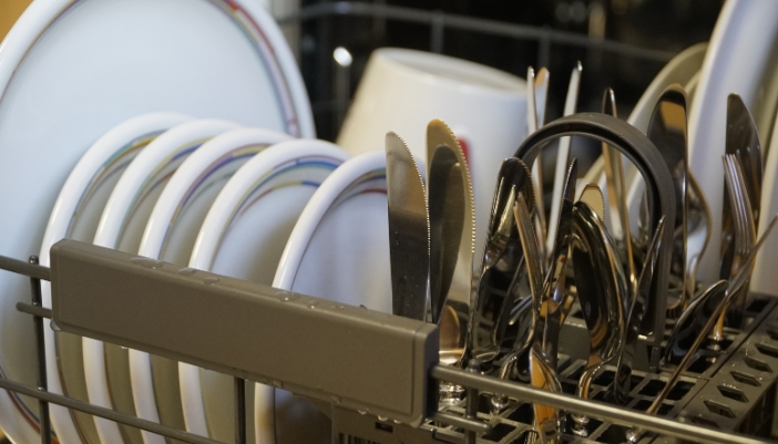 Utensil basket in a dishwasher with mixed silverware loaded handle-up and handle-down