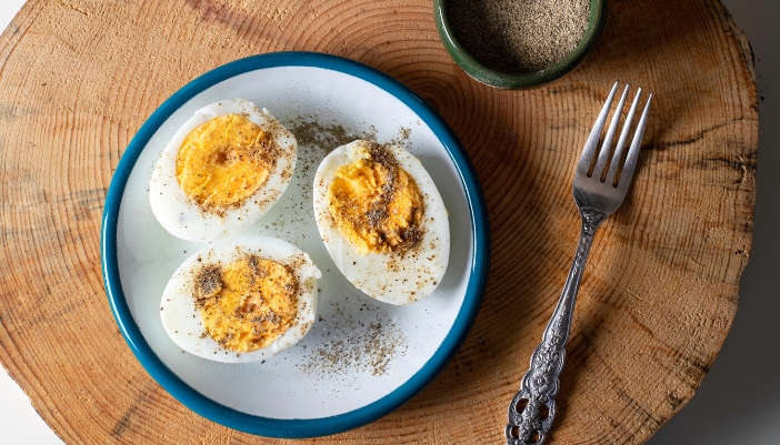 Hard boiled eggs with pepper on a plate.