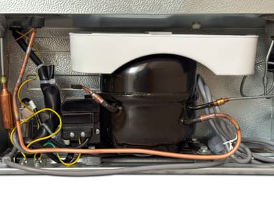A close-up of a refrigerator compressor