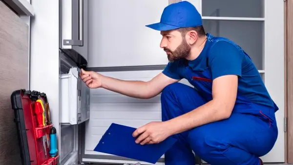 An appliance repairman inspecting an oven An appliance repairman inspecting an oven