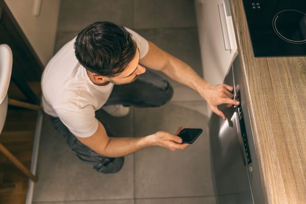 A man selecting a wash mode on a dishwasher 