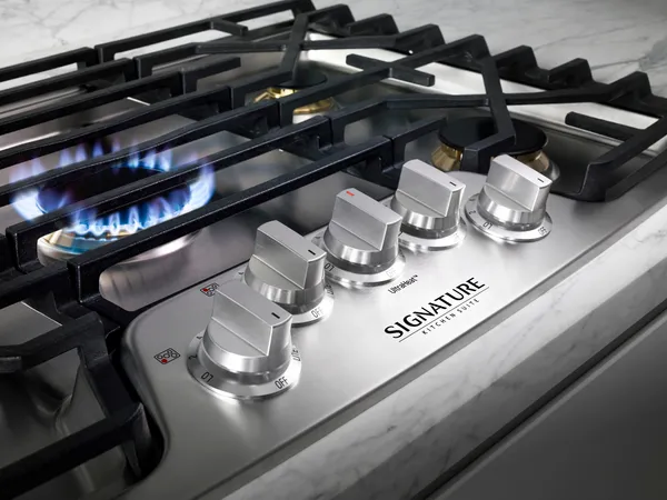 A close-up of the Signature Kitchen Suite UPCG3054ST cooktop burner