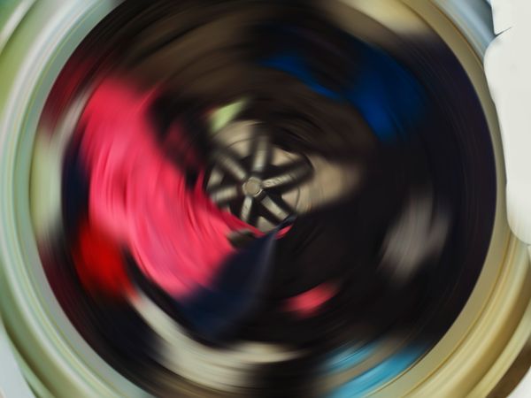 An action shot of a spinning top load washer 