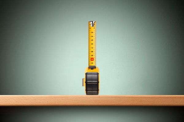 A measuring tape against a green background