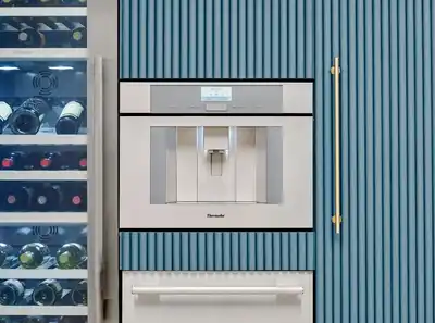 The Thermador Masterpiece TCM24TS coffee maker in custom blue wall cabinetry 