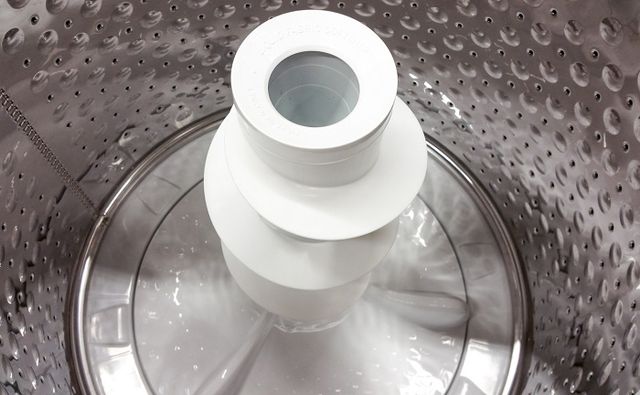 Close view of the inside of a top load washing machine with an agitator.