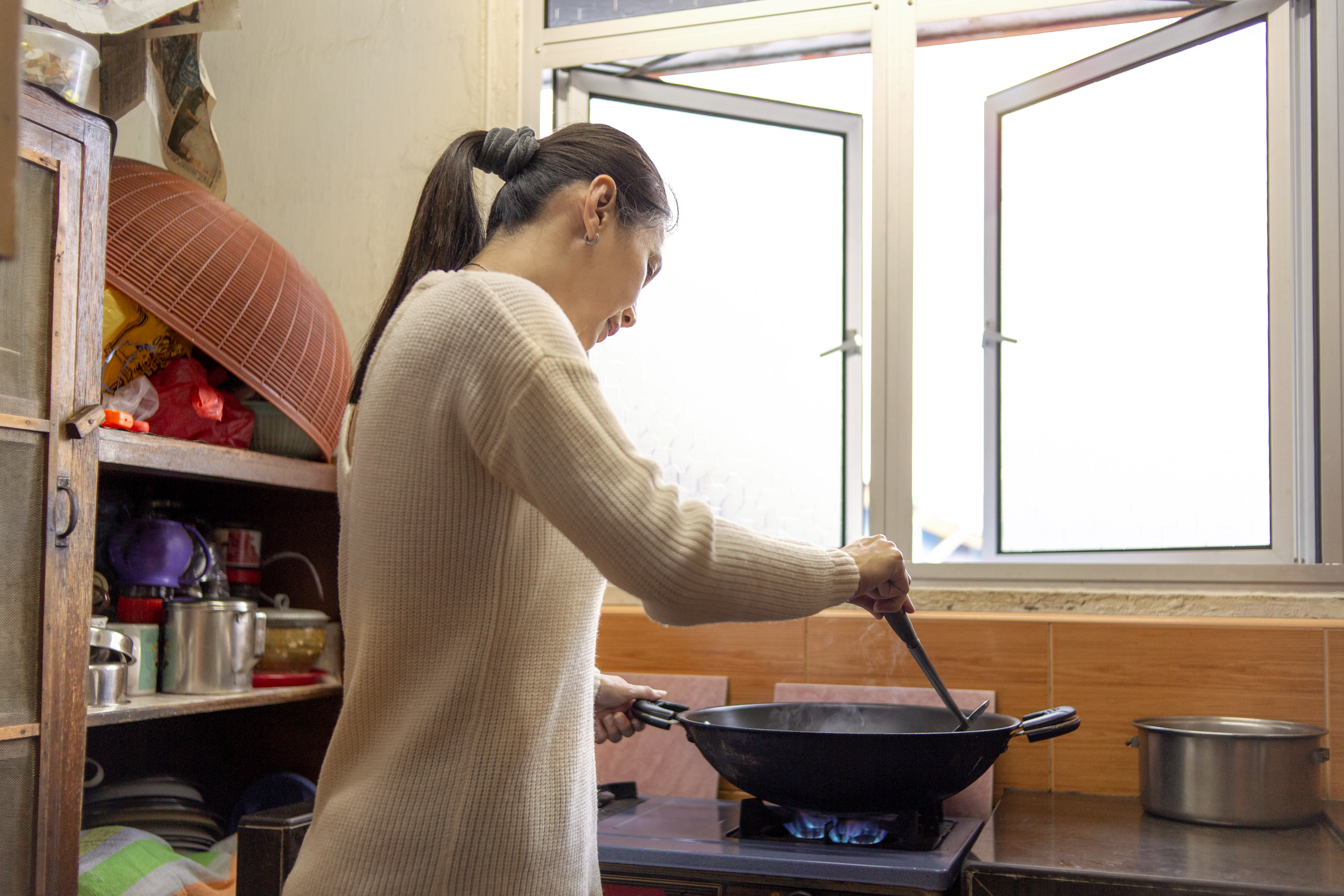 gahsoon An Asian woman cooking food inside of a wok