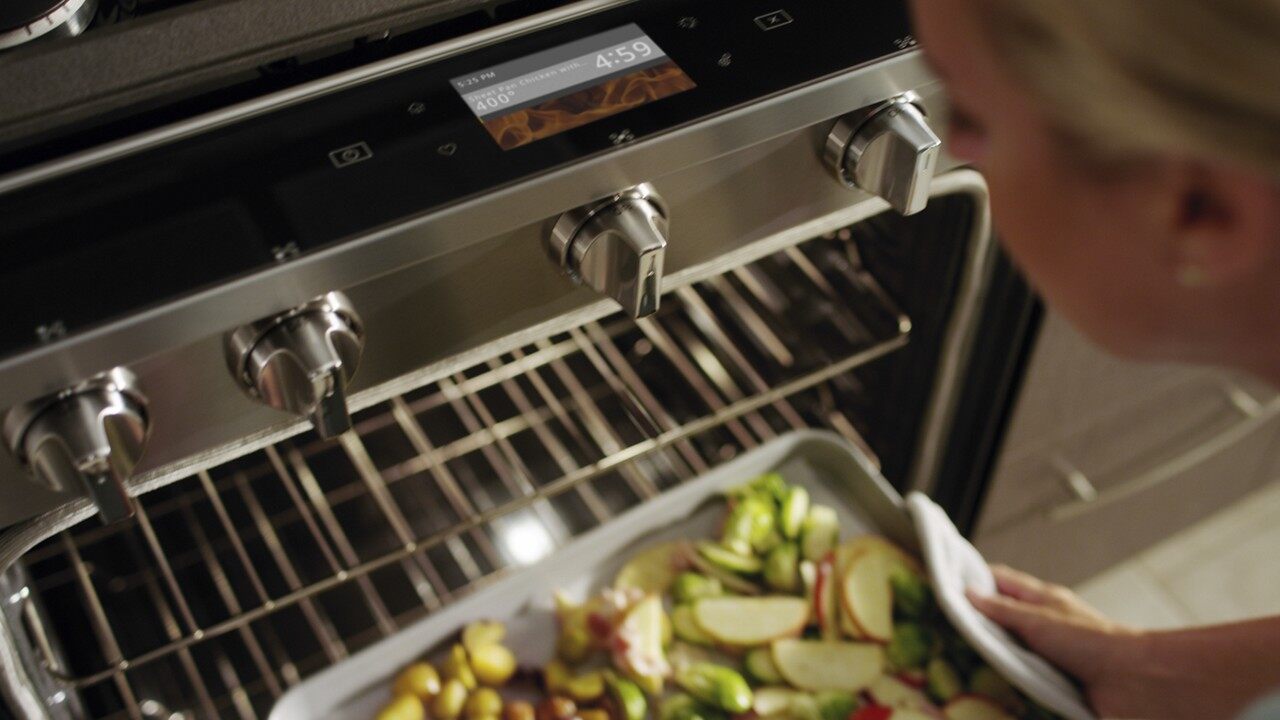 Whirlpool Images putting pan of veggies in the oven